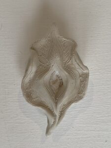 A Yoni Lamp featuring a floral design on a white pottery surface.