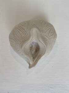 A Yoni Lamp, a white ceramic piece featuring a unique design.