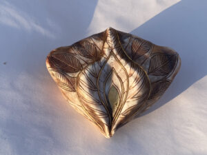 A gold leaf on a white surface.