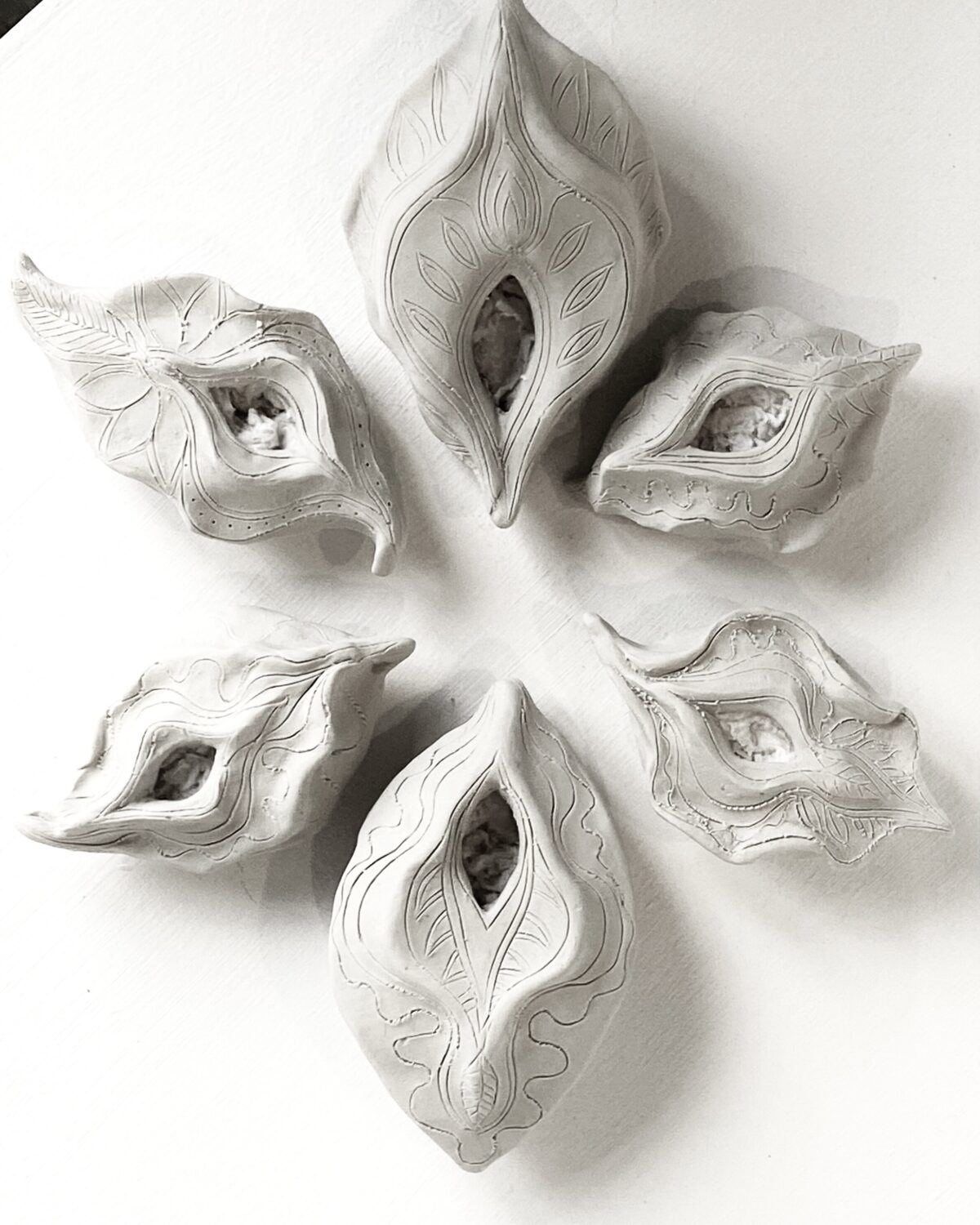 A circle of Yoni Lamps made from white clay.