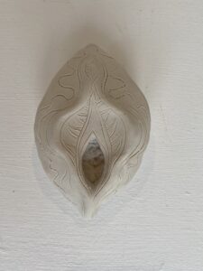 A white Yoni Lamp on a wall