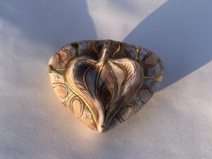 A gold heart shape on a white surface.