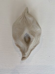 A white ceramic Yoni Lamp with a unique design.