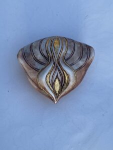 A shell with a gold design.