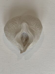 A Yoni Lamp on a white wall.