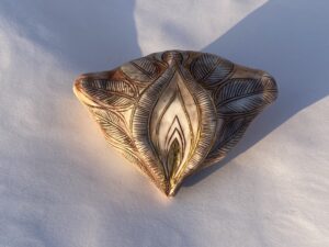 A gold leaf embellished piece of pottery.