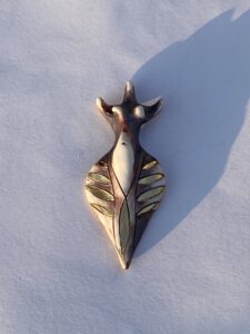 A gold pendant with a giraffe.