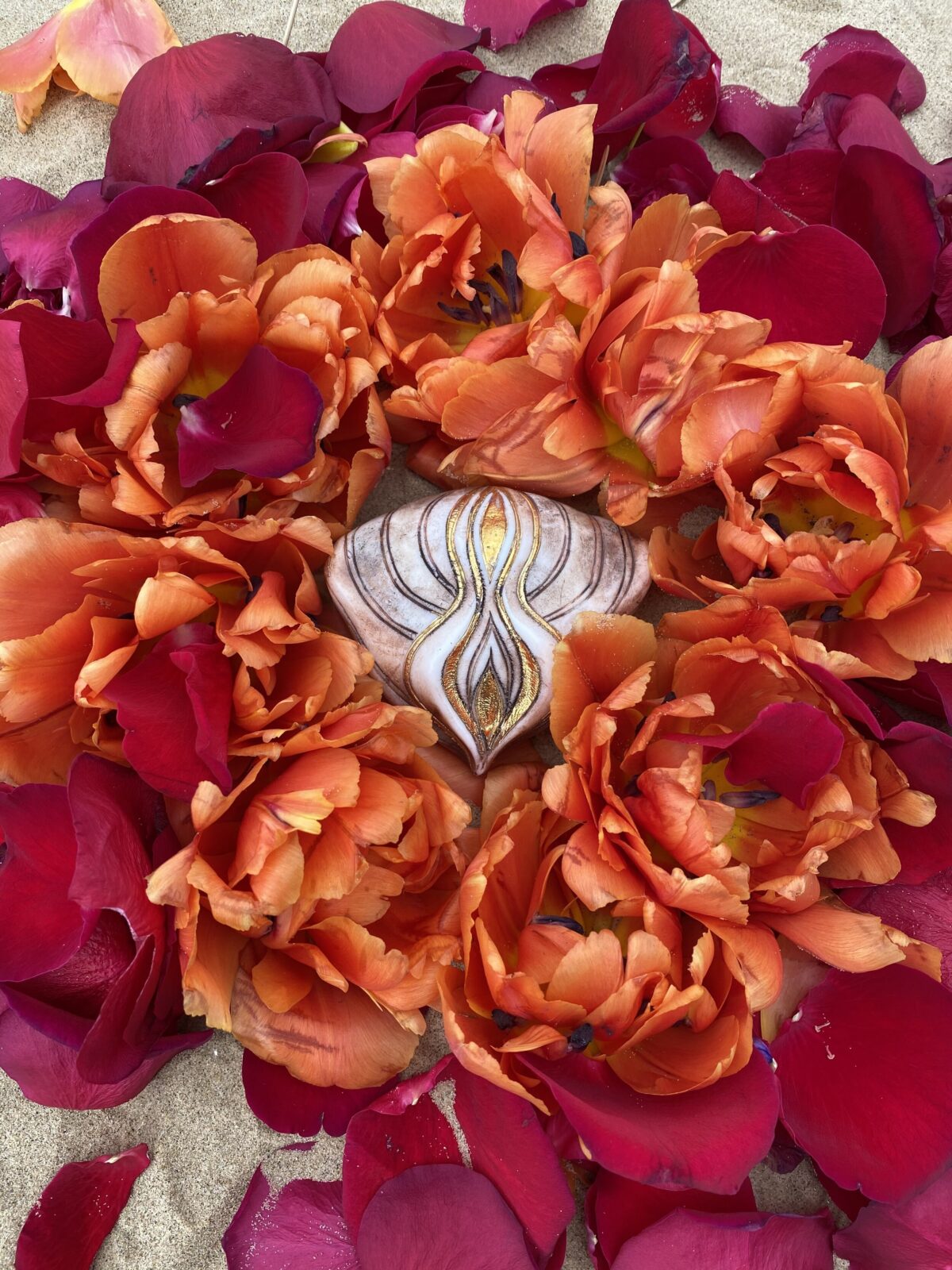 A Yoni Mandala surrounded by red and orange petals.