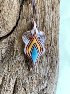 A new Yoni Talisman pendant featuring a blue and yellow design.