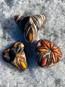 Three new Yoni Talisman stones peacefully lingered on a bed of untouched snow.