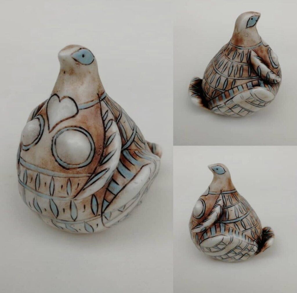 A pair of ceramic birds with different designs on them.