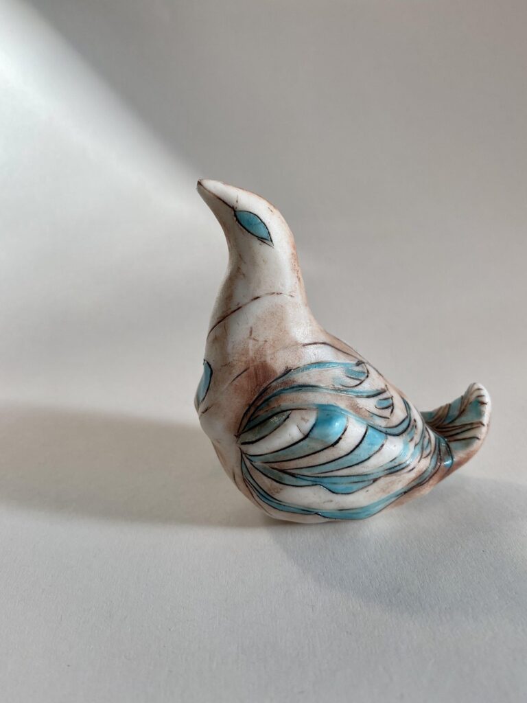 A ceramic bird with a blue and white pattern.