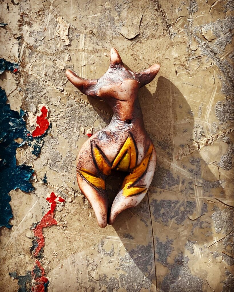 A sculpture of a deer sitting on a wall.