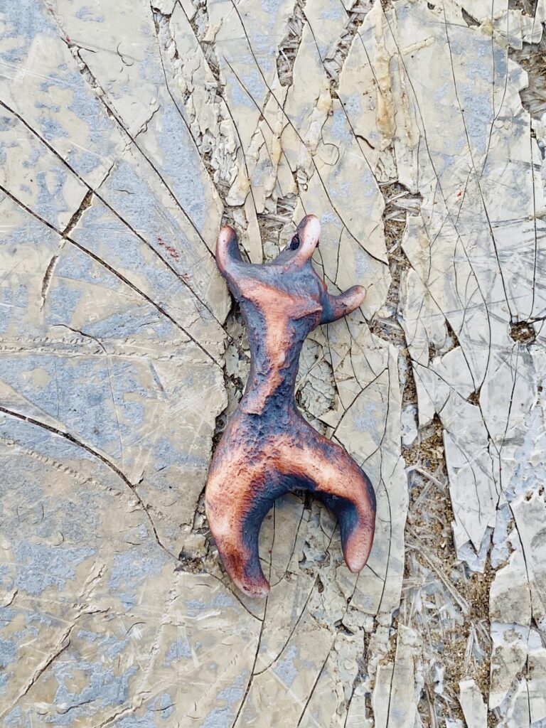 A piece of wood is sitting on a broken piece of rock.