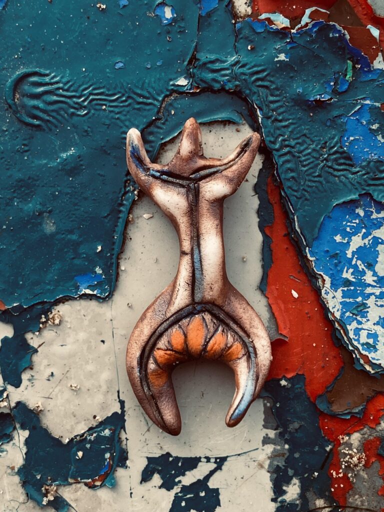 A sculpture of a giraffe sitting on a wall.