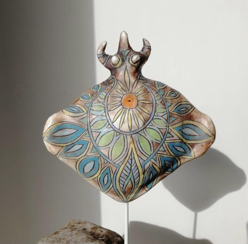 A ceramic sculpture of a sea creature sitting on a rock.