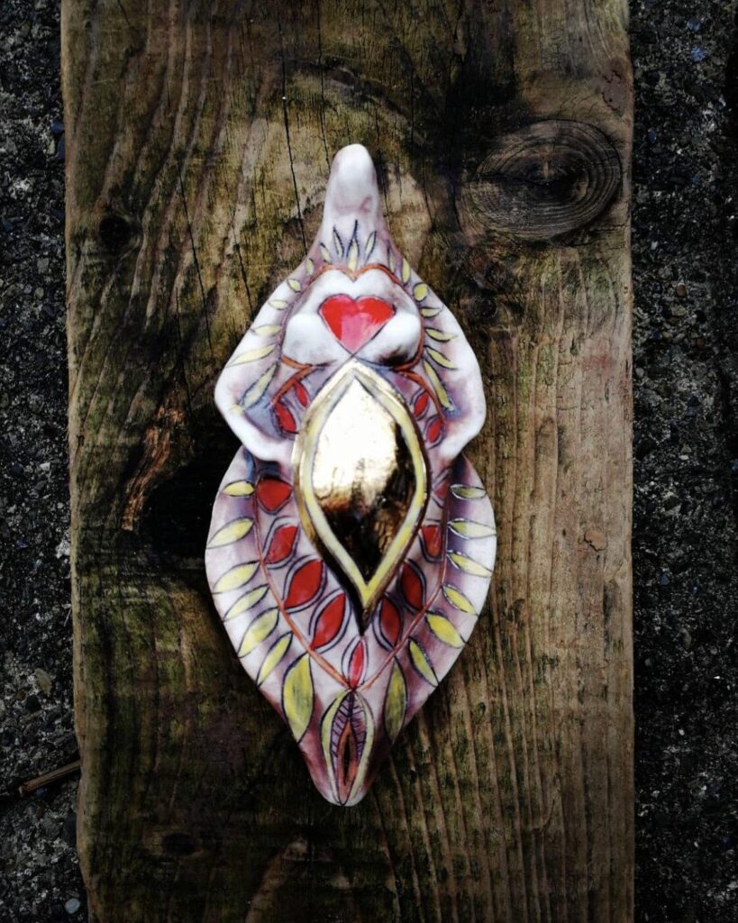 A ceramic shell with a gold ring on it.