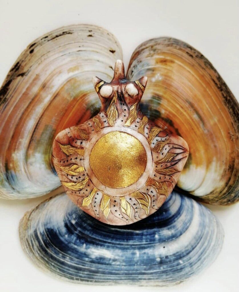 A clam shell with a sun on it.
