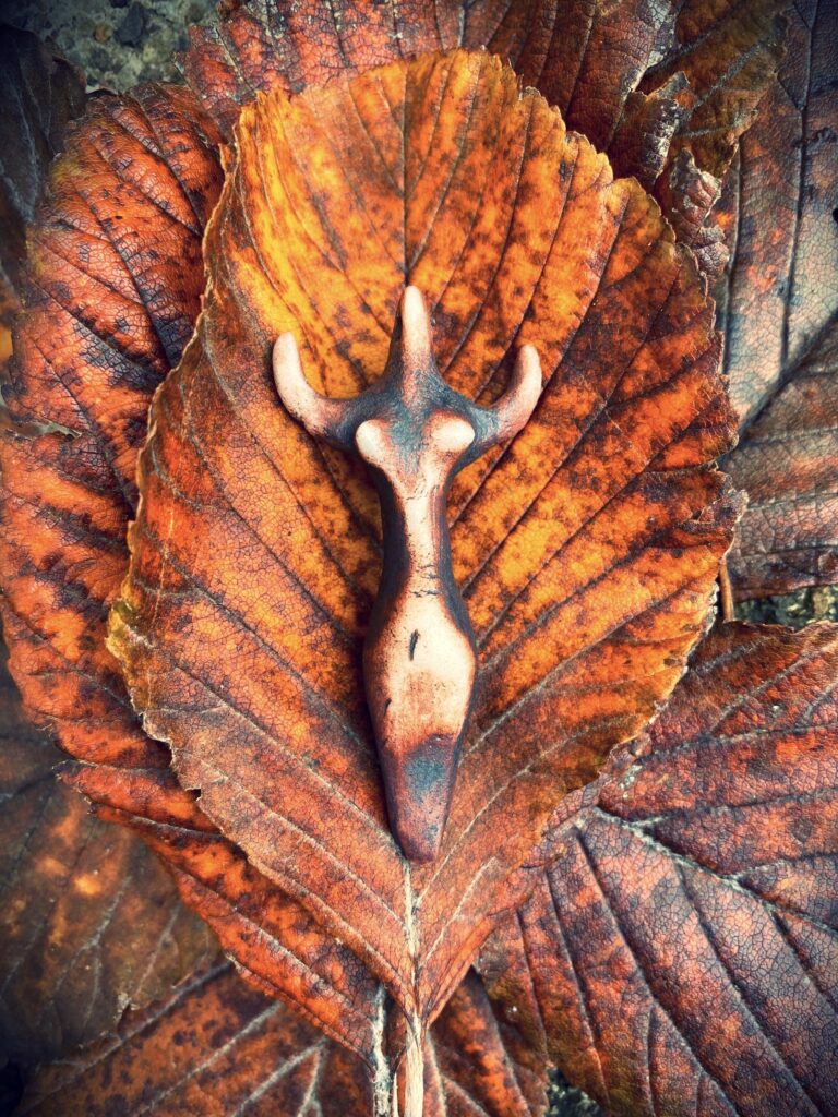 A horned head is sitting on top of a leaf.