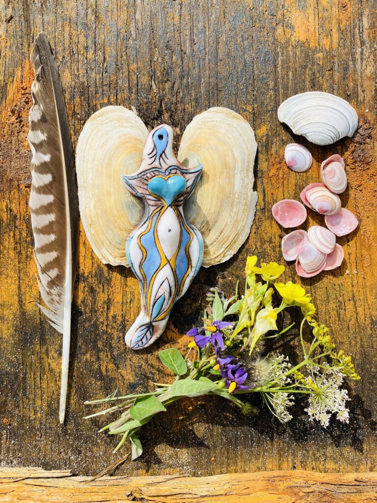 Angels, feathers, shells and flowers on a wooden table.