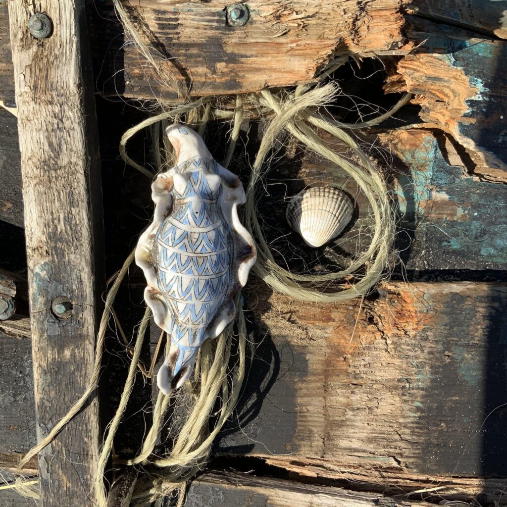 A blue and white sea shell on a wooden crate.