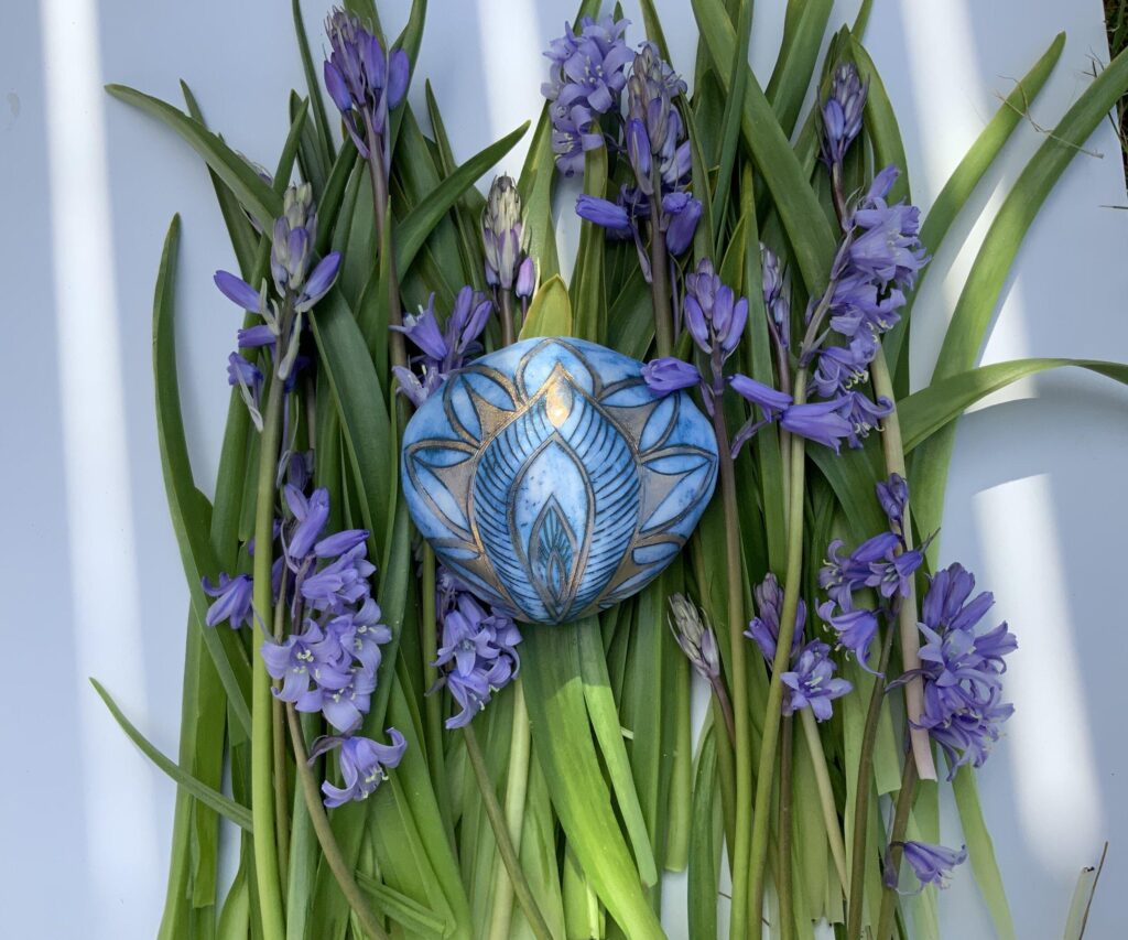 A blue stone surrounded by purple flowers.