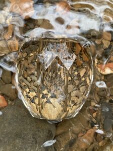 A crystal bead is floating in a stream of water.