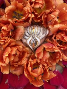 A Yoni Mandala adorned with orange tulips.