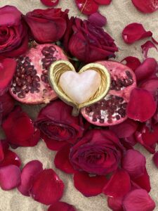 A Yoni Mandala featuring a heart-shaped pomegranate adorned with rose petals.
